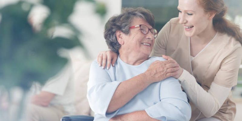 Happy patient is holding caregiver for a hand while spending time together